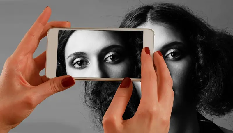En kvinne blir fotografert med en smarttelefon